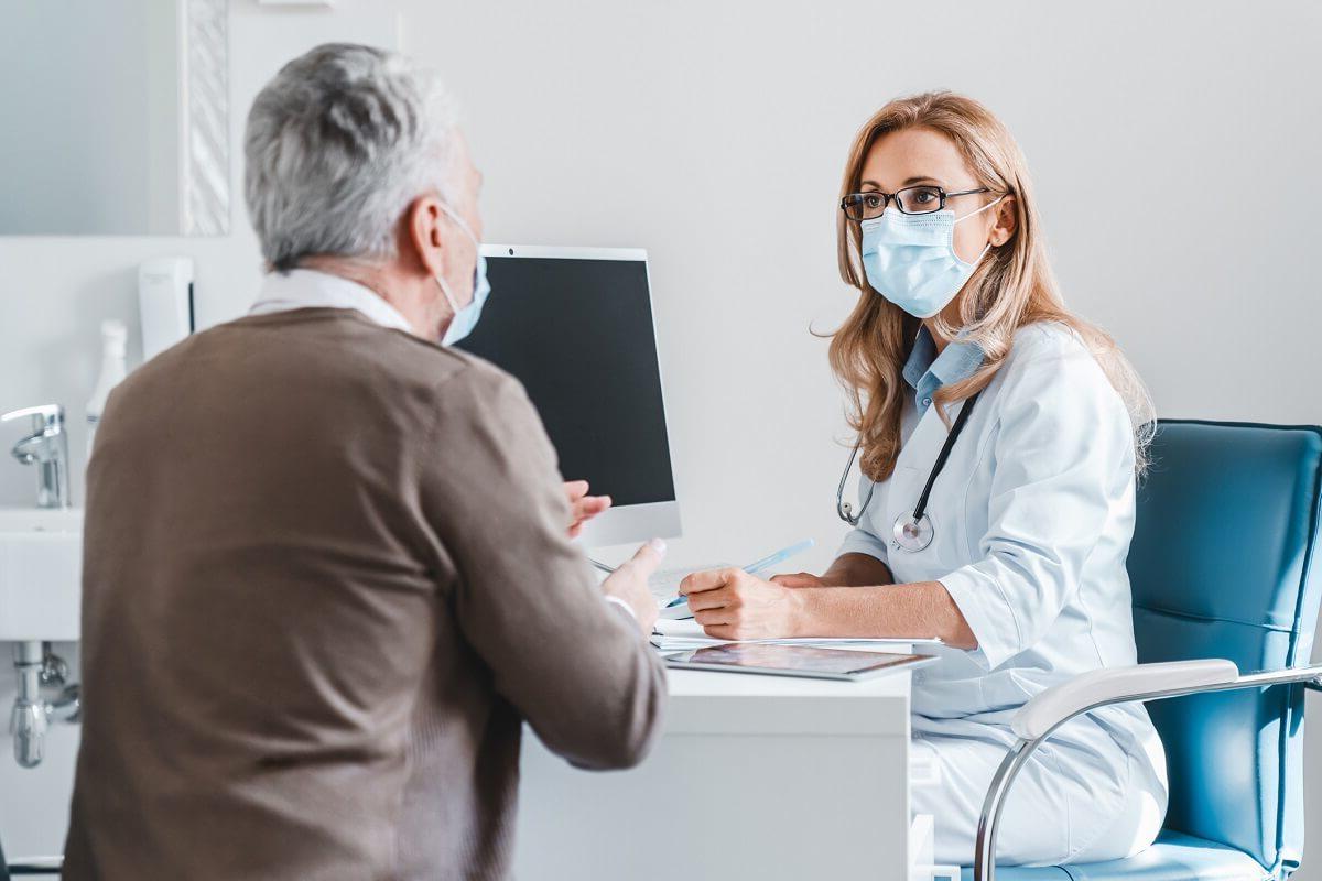 Adult Gerontology Nurse Practitioner in Mask Consulting with Adult Patient