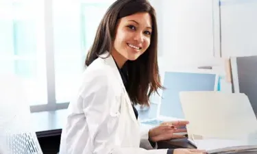 Medical Billing and Coding Specialist Smiling at Desk