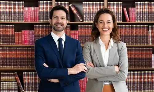 Legal Studies Graduates Smiling in Front of Bookshelves