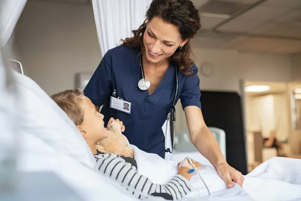 Nurse Smiling with Pediatric Patient in Hospital